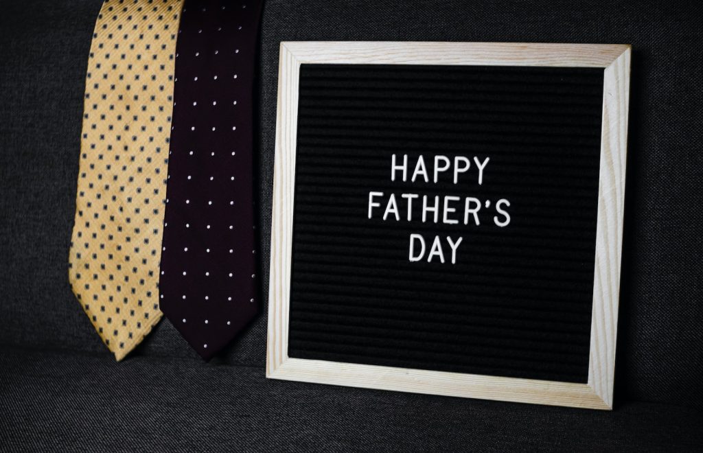 a father's day sign next to two ties